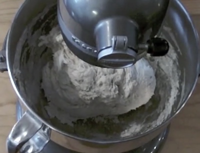 an electric stand mixer mixing bread dough.
