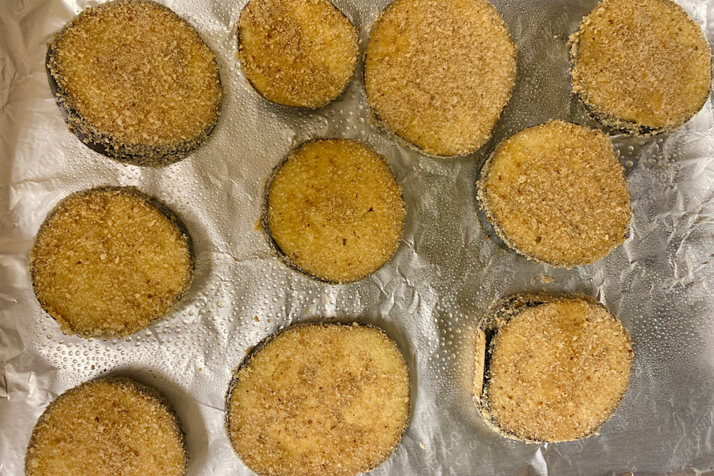 Ten Breaded eggplants discs ready to be baked.