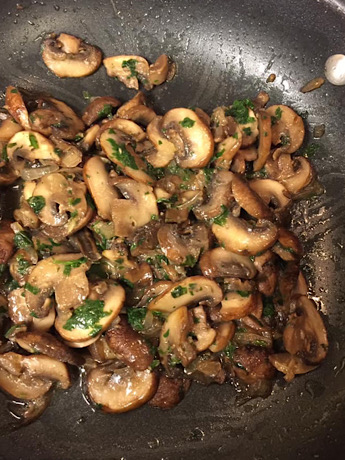 A frying pan with sautéed mushroom 