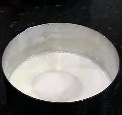 A saucepan with milk and sugar to make a sugar glaze for sweet coconut  bread topping recipe.