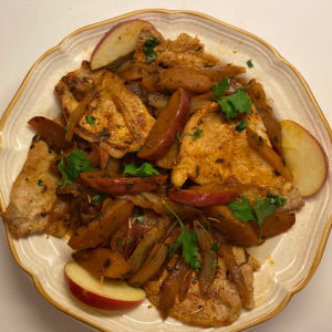 Plate with boneless pork chops with onions and apples